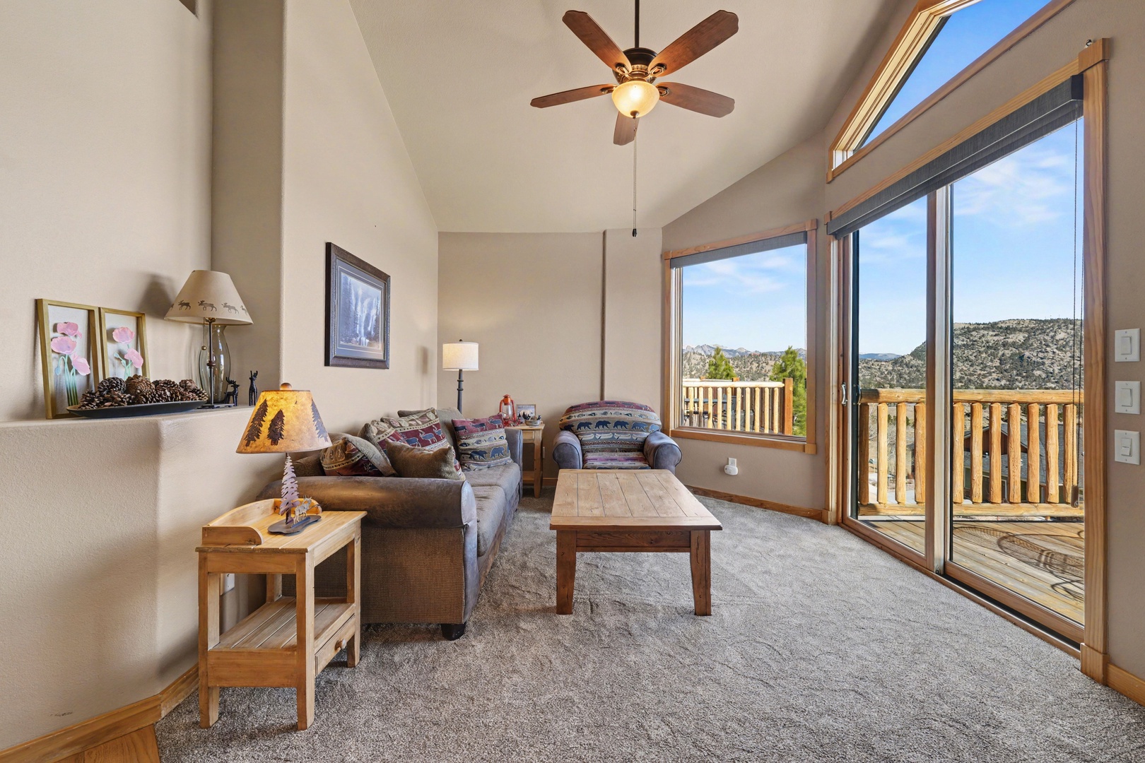 Unwind in this bright living room with cozy seating, and beautiful mountain views through floor-to-ceiling windows.