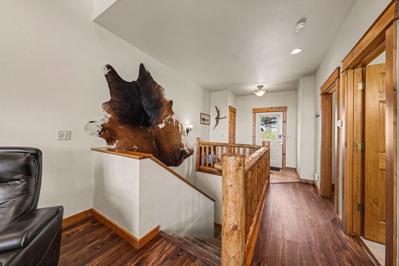 Step into your mountain retreat through this welcoming entryway, where rustic charm meets comfort with warm wood tones and unique artistic touches that set the tone for your stay.