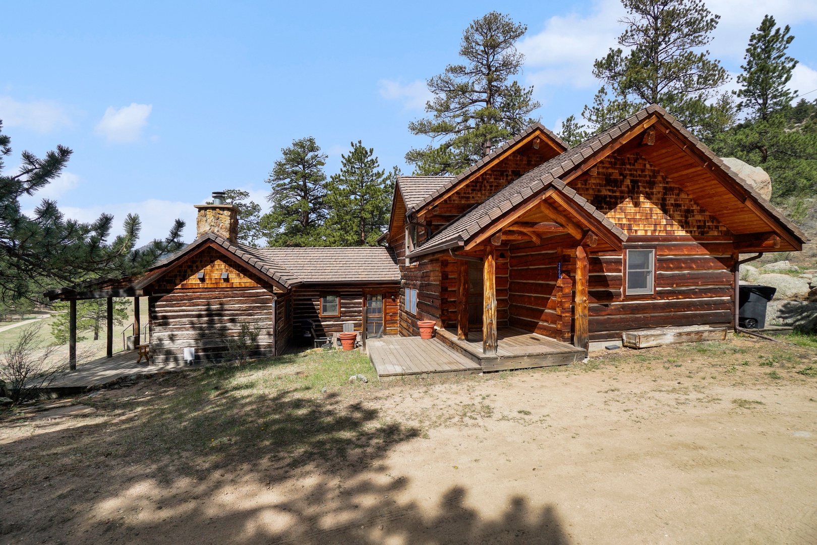 Rustic log cabin retreat nestled among towering pines, featuring authentic wood construction and peaceful mountain surroundings for your perfect getaway.