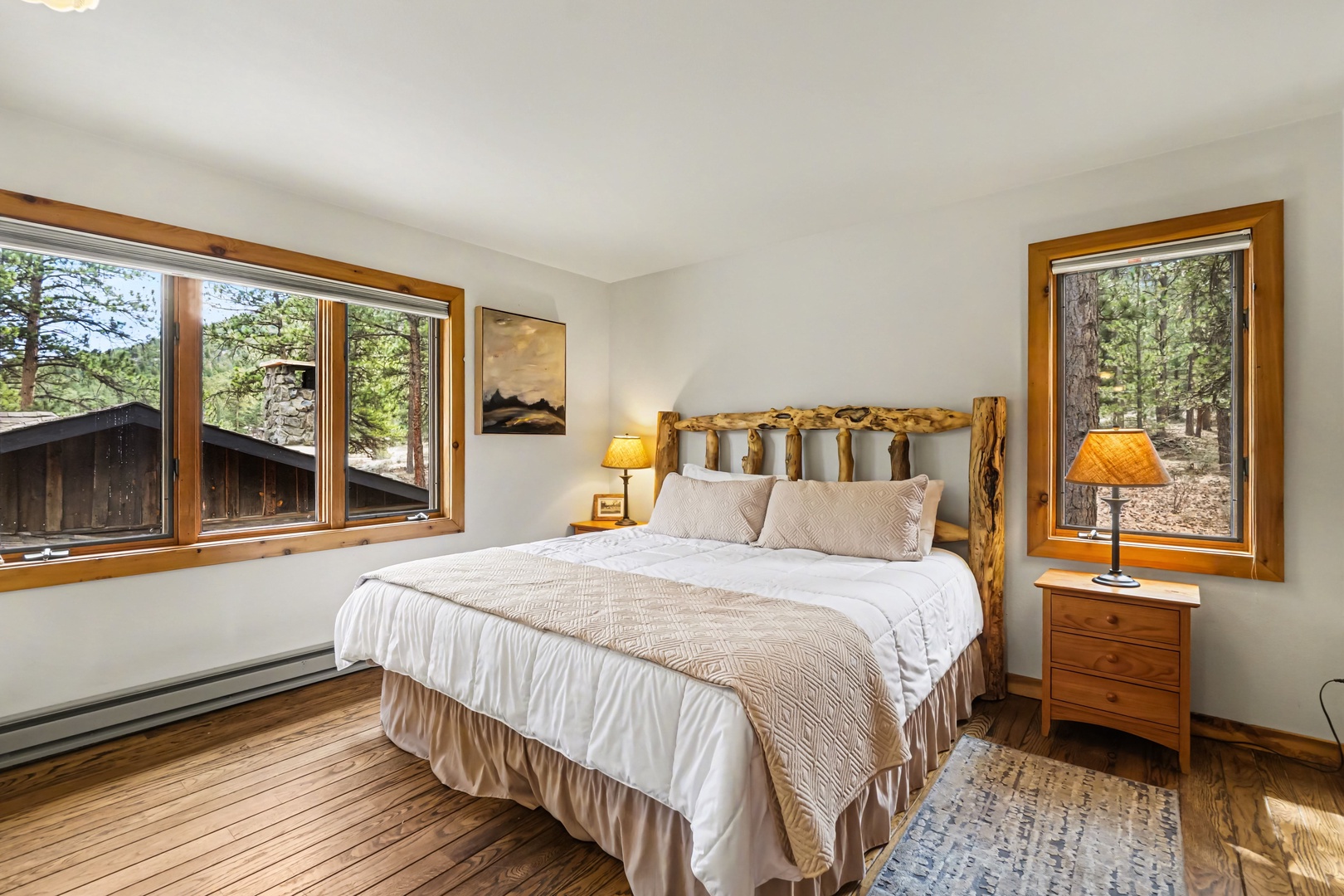 Wake up surrounded by forest views in your cozy bedroom, where natural wood accents and soft linens create the perfect mountain retreat sanctuary.