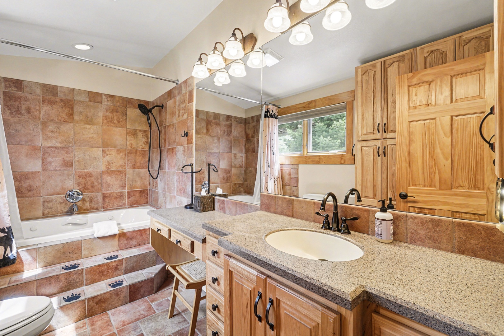 Step into your private spa-like bathroom with beautiful stone tile, soaking tub, and warm wood finishes that create the perfect retreat.