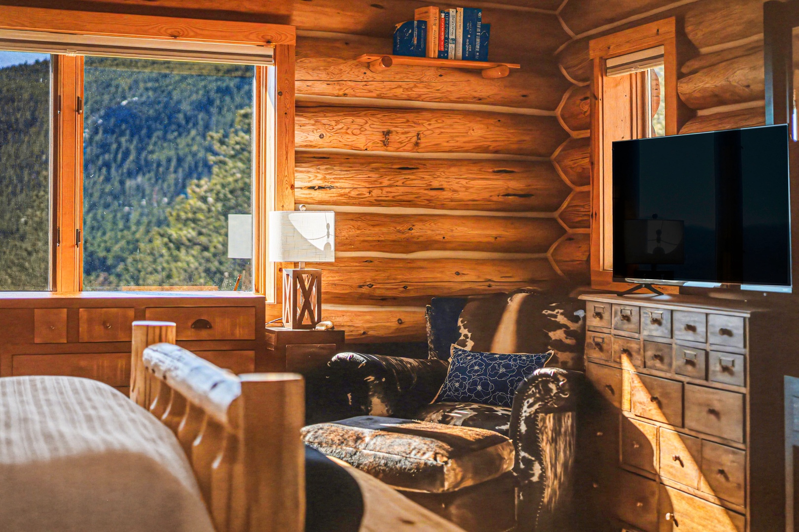 Cozy up in this rustic log cabin retreat where warm wood surrounds you and mountain views fill the windows.