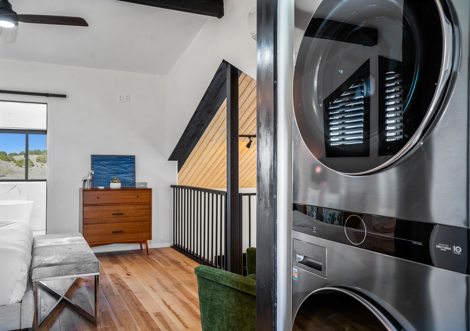 Your stylish loft combines comfort and convenience with a modern washer-dryer unit beside warm living spaces and stunning views.