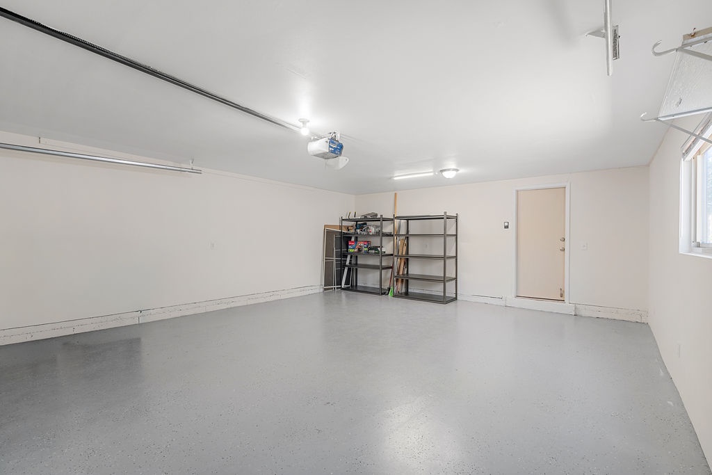 Spacious garage with convenient storage shelving and automatic door opener for your rental car and gear.