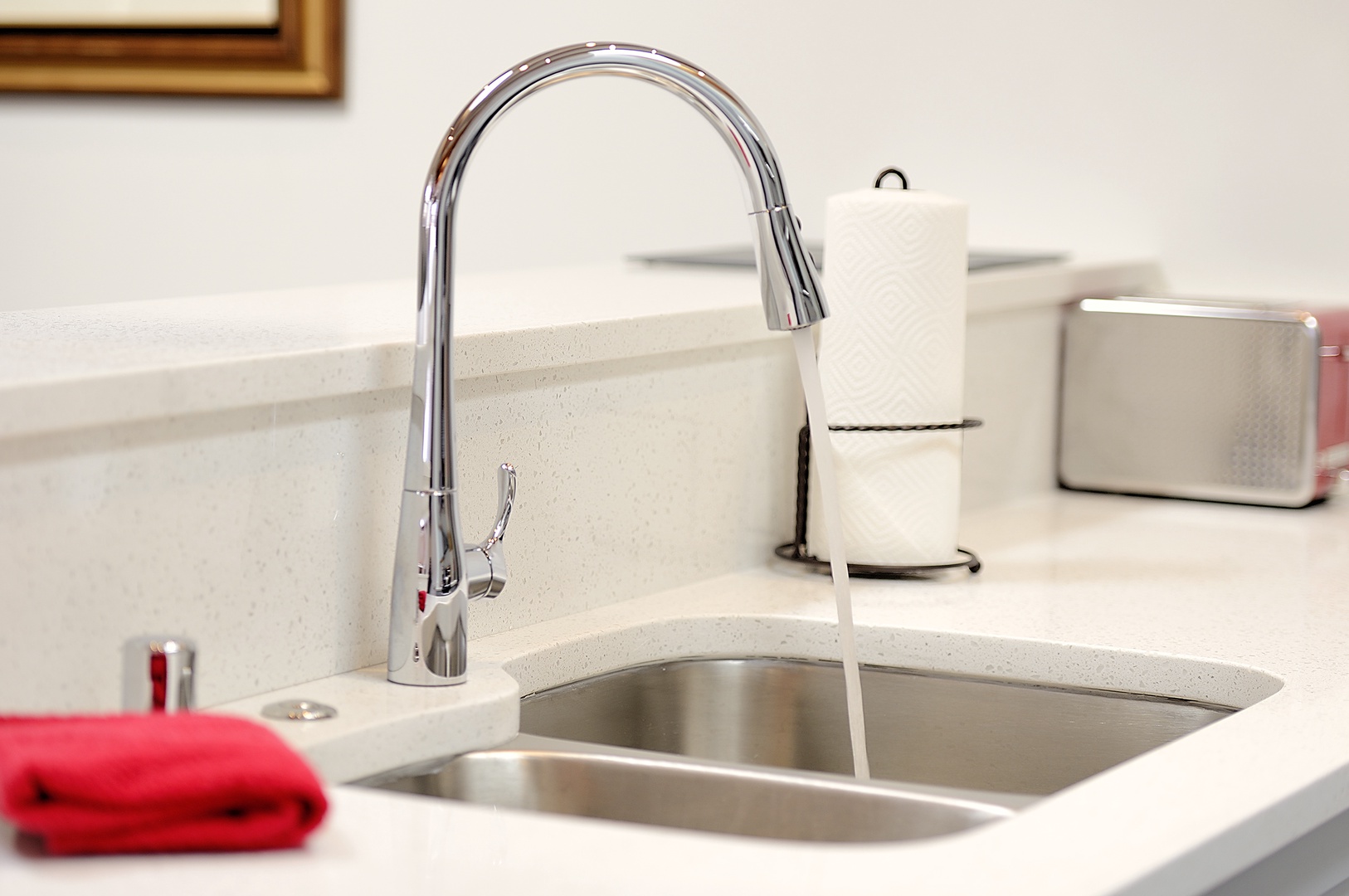Your modern kitchen sink features a sleek pull-down faucet with clean quartz countertops, perfect for easy meal prep and cleanup.