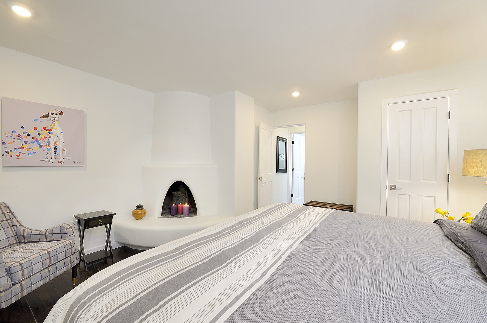 Unwind in your peaceful bedroom featuring a cozy fireplace, comfortable seating nook, and warm ambient lighting for ultimate relaxation.