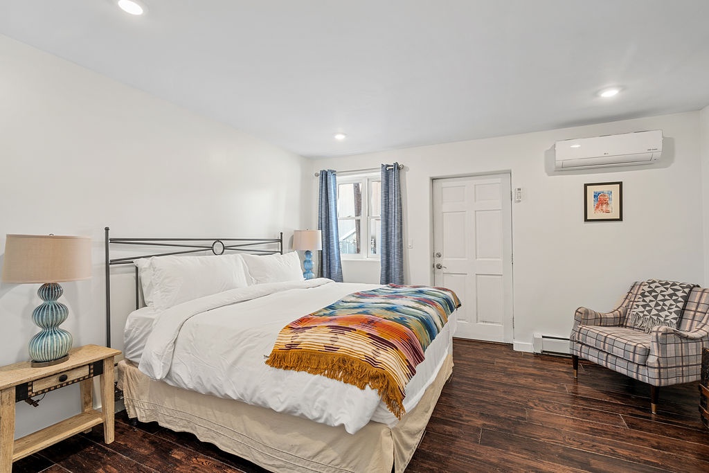 Rest peacefully in this stylish bedroom with crisp white linens, a colorful throw blanket, and your own reading nook by the window.