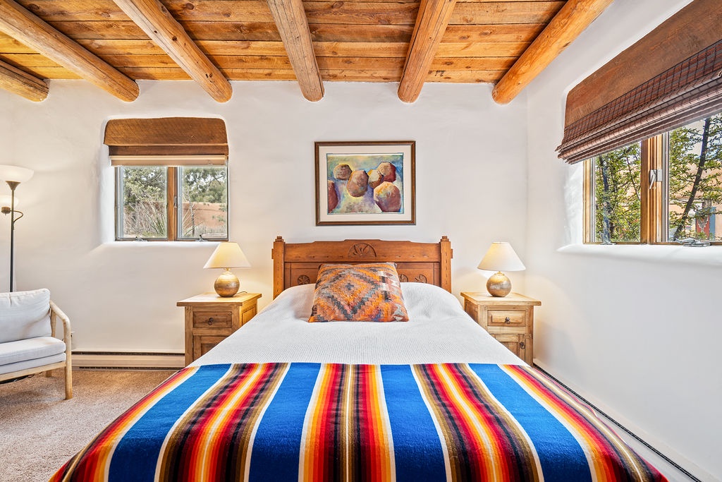 Drift into peaceful sleep beneath rustic wood beams, wrapped in vibrant southwestern textiles that bring warmth to your serene retreat.