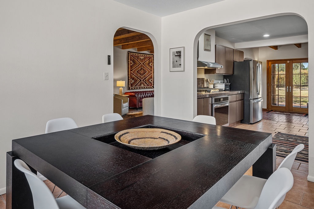 Gather around this stunning dark wood dining table, perfect for memorable meals with loved ones in this bright, open space.