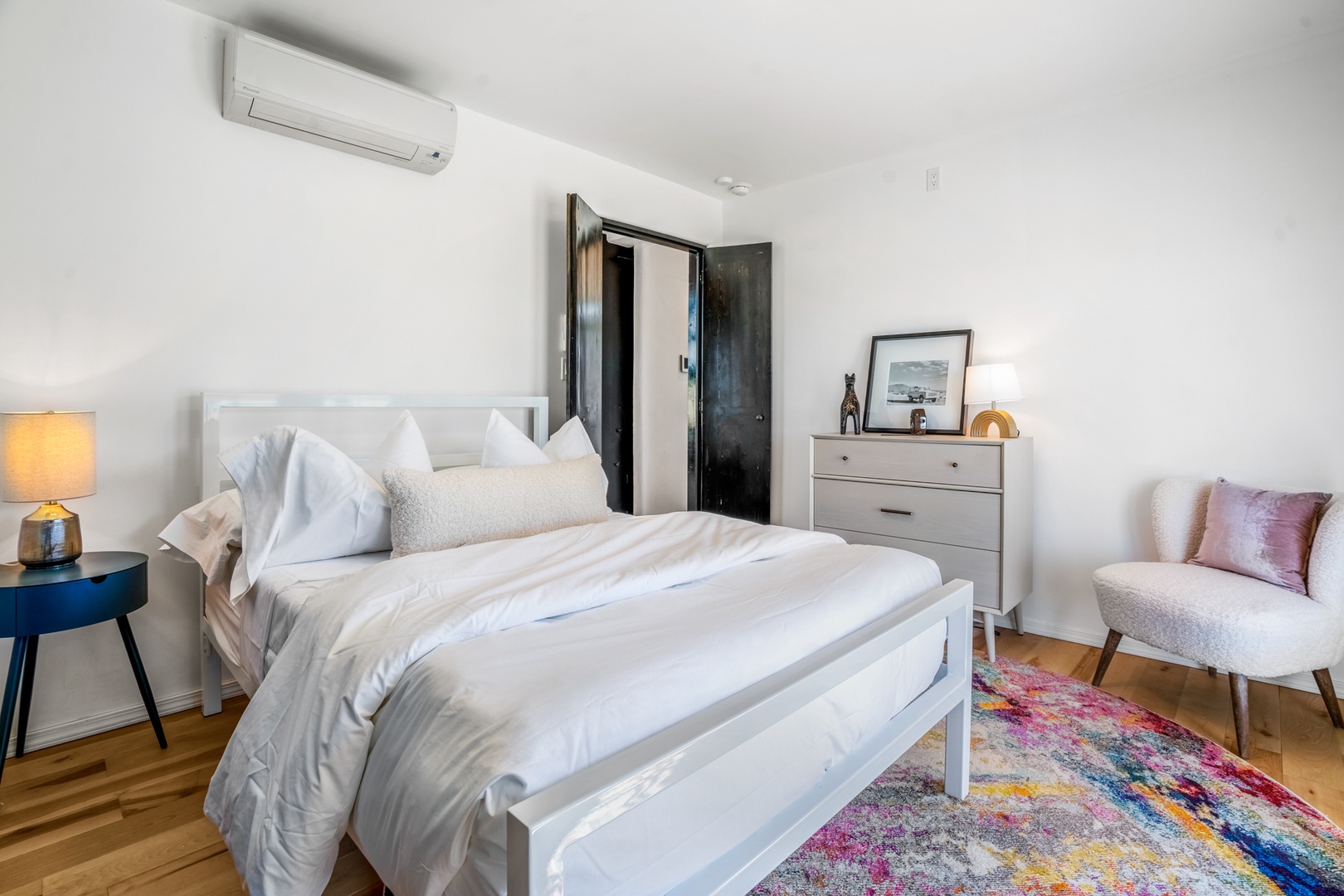 Sink into crisp white linens and enjoy modern comfort with AC cooling, stylish furnishings, and a cozy reading nook.