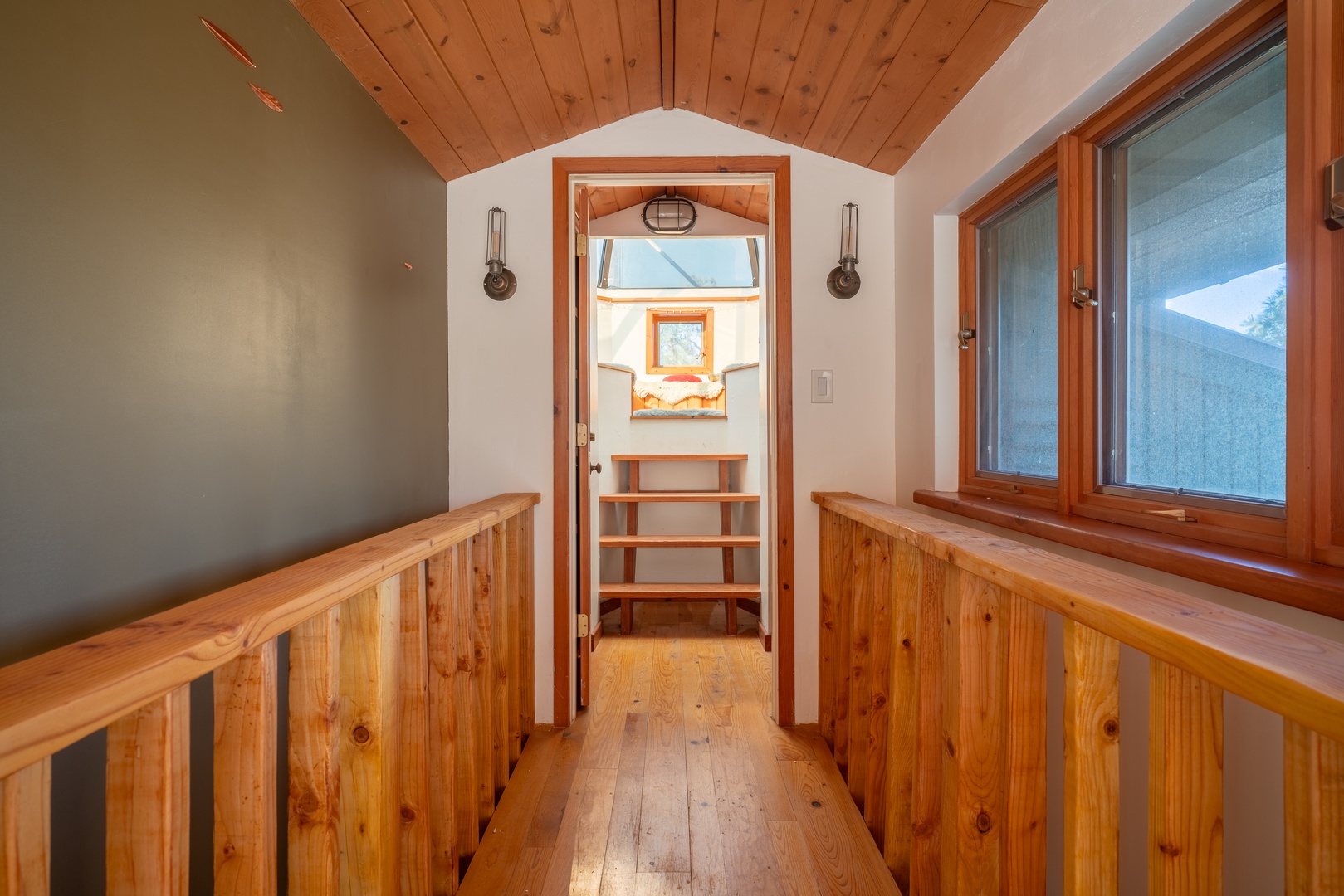Step into your cozy loft space, where warm wood finishes and natural light create a welcoming retreat with a meditation dome just beyond the arched doorway.