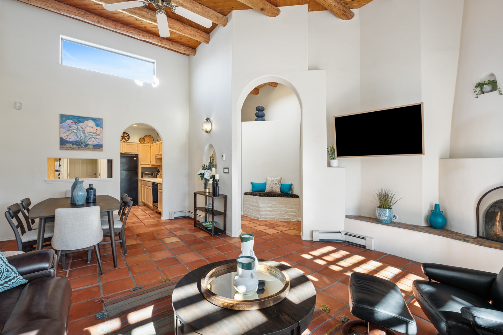 Relax in this stunning open-concept living space with soaring wood beam ceilings, cozy fireplace, and southwestern charm that invites you to unwind in style.