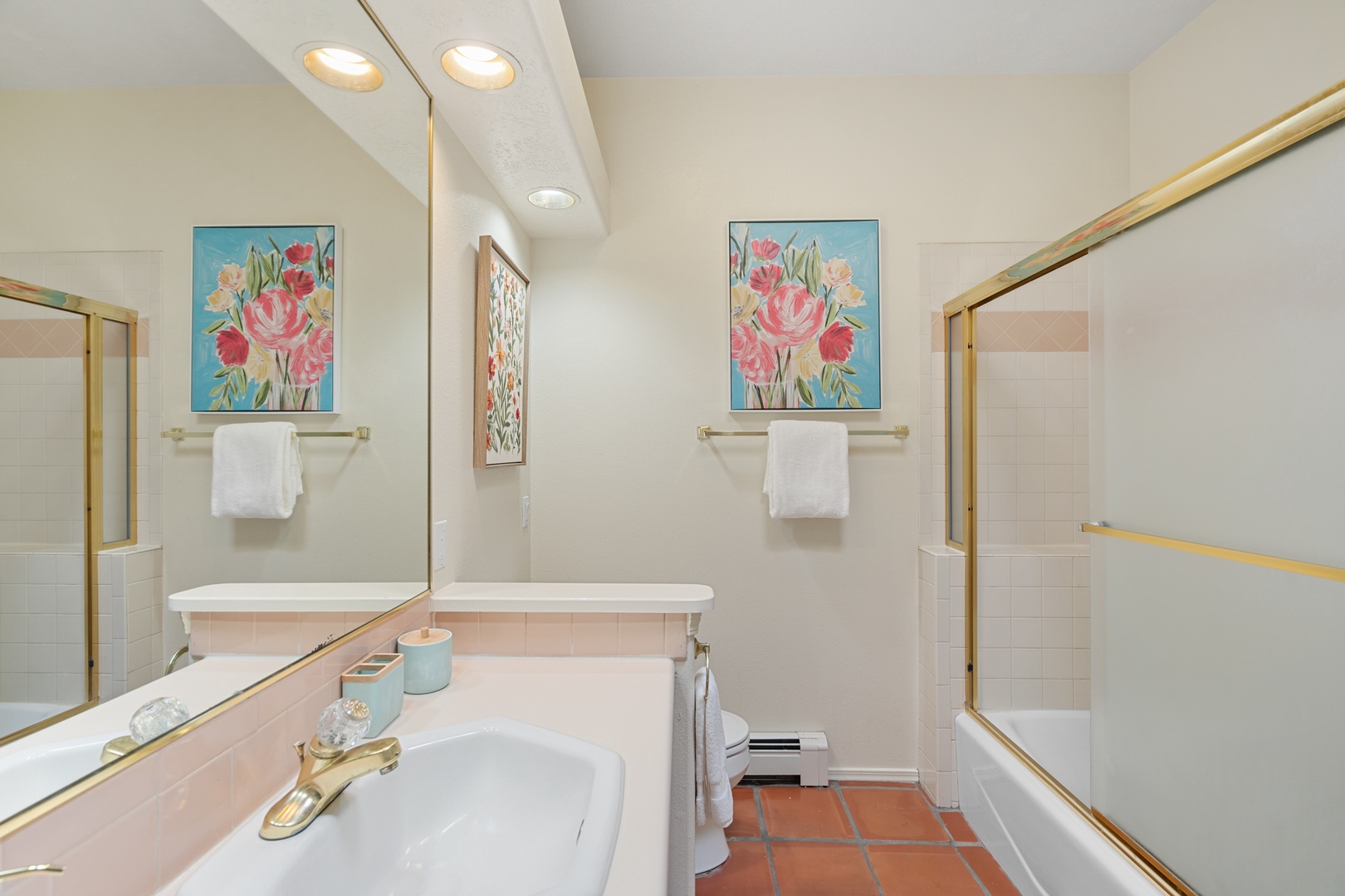 Freshen up in your bright, well-appointed bathroom featuring a spacious vanity, cheerful floral artwork, and everything you need for a comfortable stay.