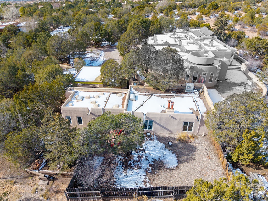 Aerial view showcasing the unique architectural design of this distinctive southwestern-style property surrounded by natural desert landscape.