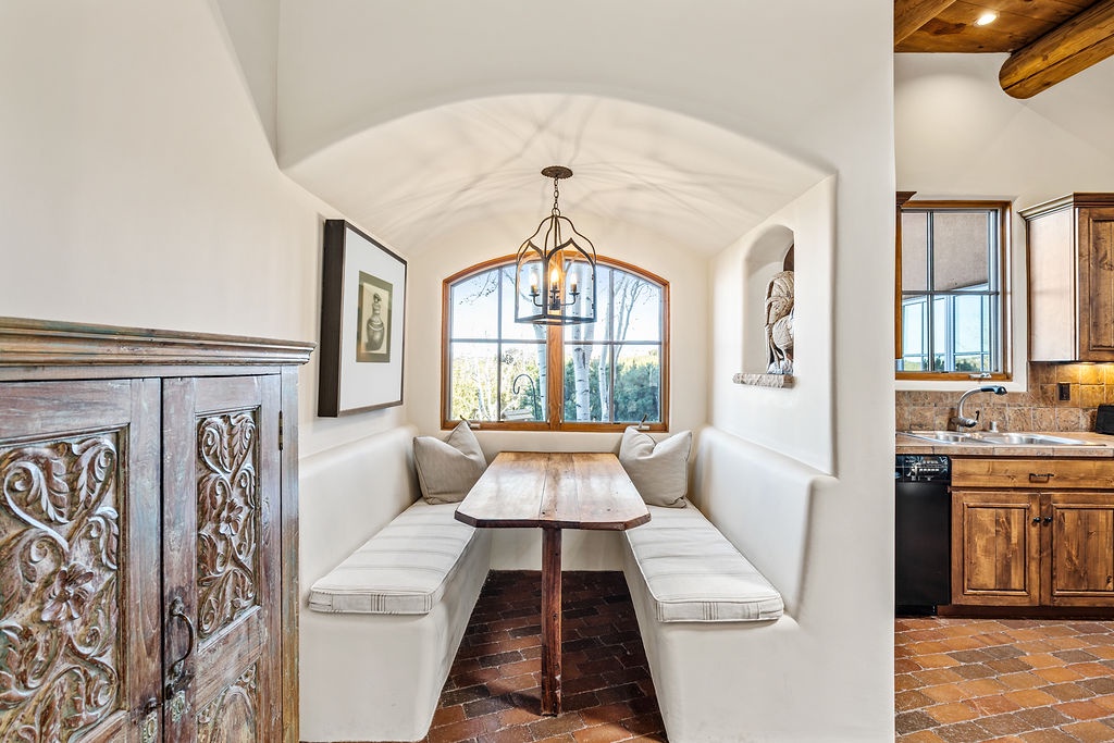 Your cozy breakfast nook features built-in seating with soft cushions, perfect for morning coffee while watching the sunrise through arched windows.