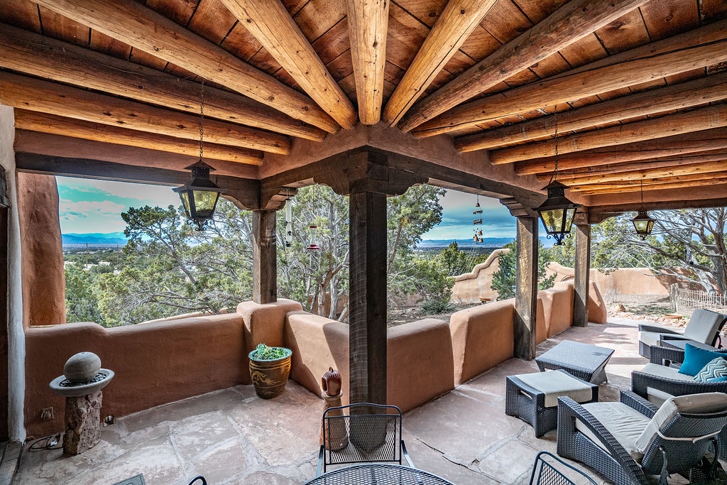 Relax under soaring wooden beams on your covered terrace, where rustic charm meets stunning desert views and comfortable seating awaits.