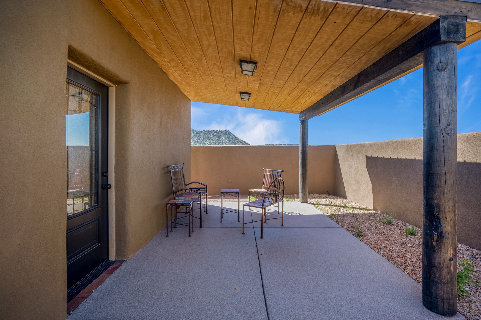 Step onto your private covered patio where mountain views stretch beyond rustic walls, perfect for morning coffee or evening relaxation.