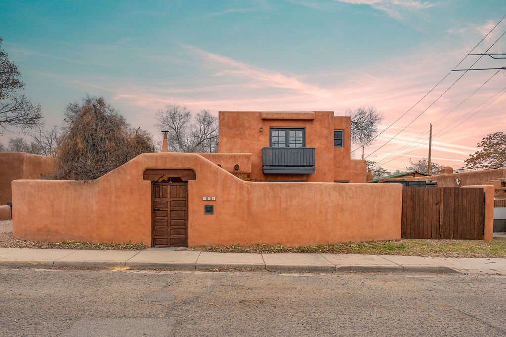 Distinctive adobe-style property featuring traditional southwestern architecture with warm earth tones and authentic wooden entrance details.