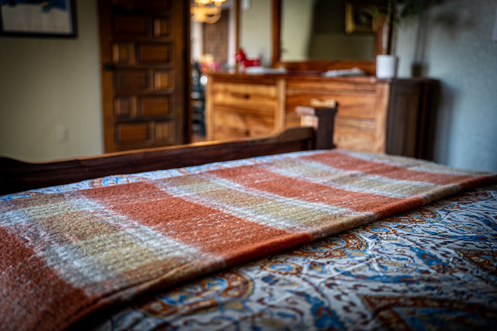 Sink into your cozy bed wrapped in beautiful quilts, where rustic charm meets comfort in this thoughtfully appointed bedroom.