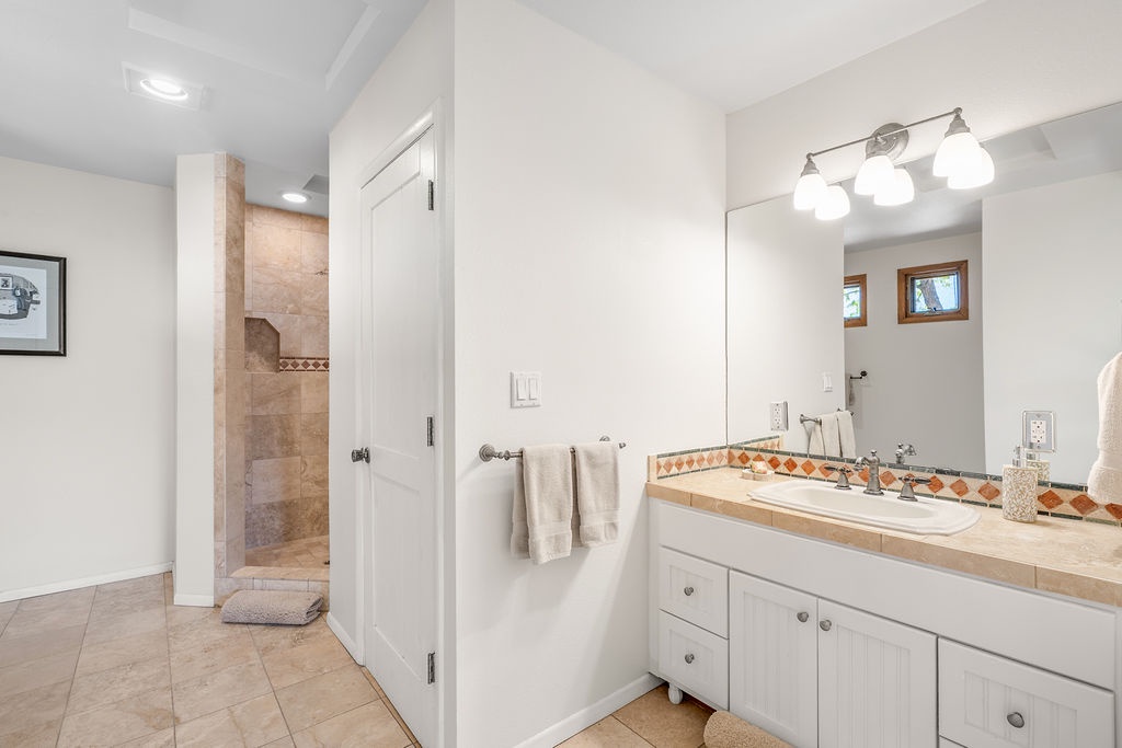Your spacious bathroom features elegant tile work, a vanity with ample storage, and a separate tiled shower for your comfort.