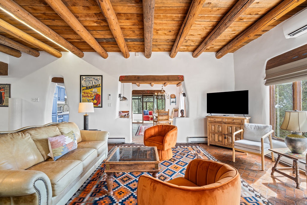 Unwind in this stunning living room where rustic wooden beams meet colorful Southwest charm, complete with plush seating and modern entertainment.