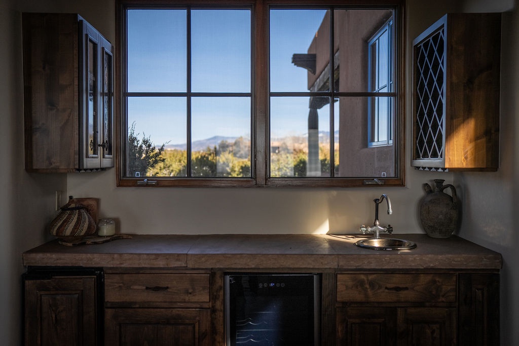 Your rustic kitchen welcomes you with warm wood cabinetry and stunning mountain views through the window as golden light streams across the counters.