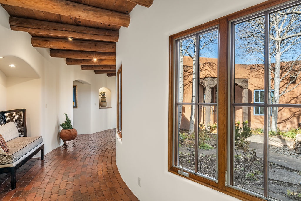 Relax in your charming living space with exposed wooden beams and brick floors, where natural light streams through windows.