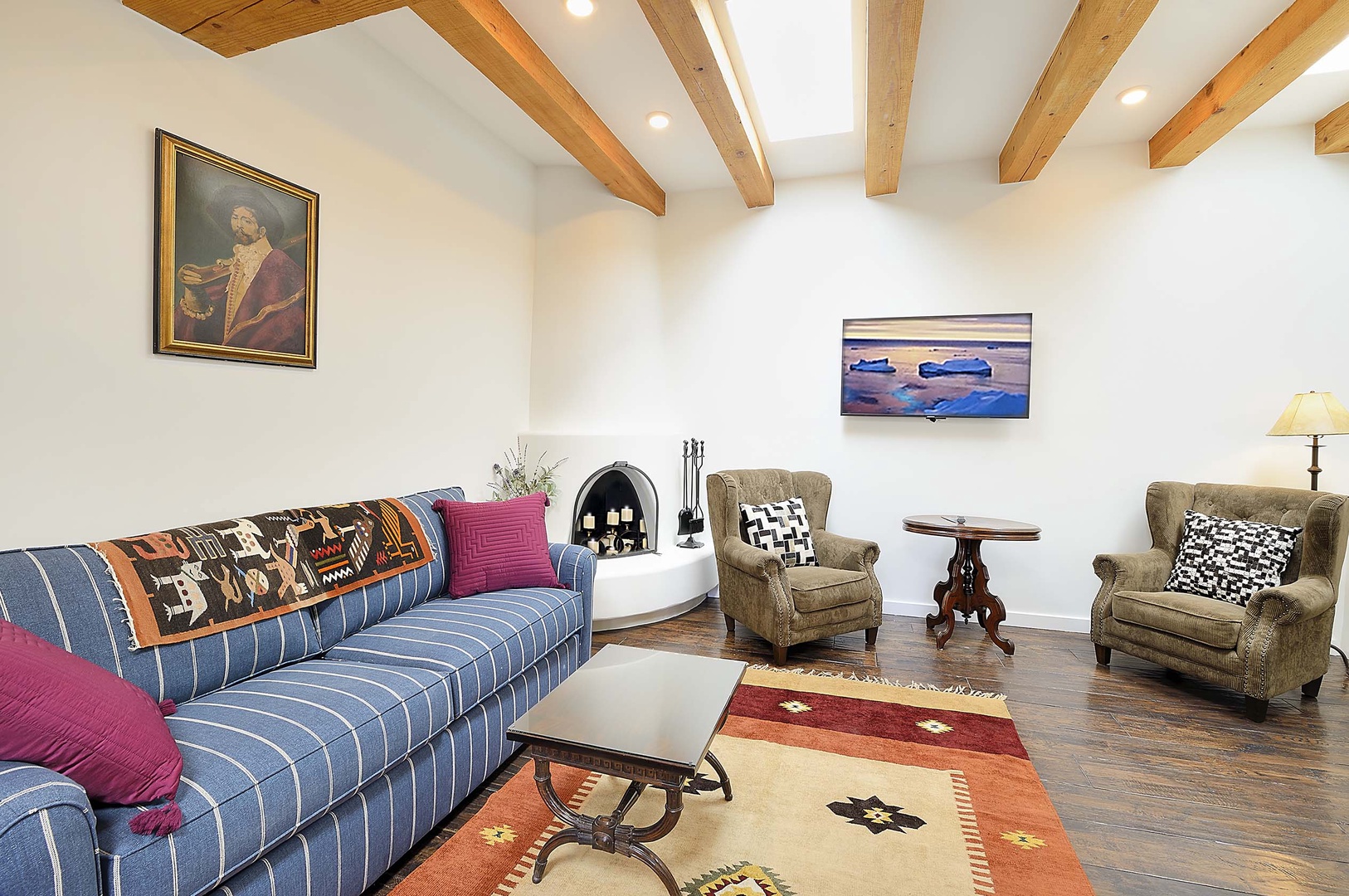 Relax in your spacious living room featuring exposed wooden beams, cozy fireplace, and comfortable seating perfect for unwinding after adventures.
