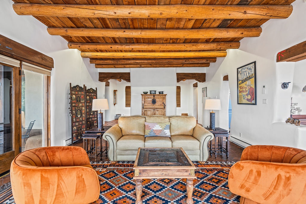 Relax under stunning exposed wooden beams in this beautifully appointed living room, where rich leather seating and Southwestern charm create your perfect retreat.