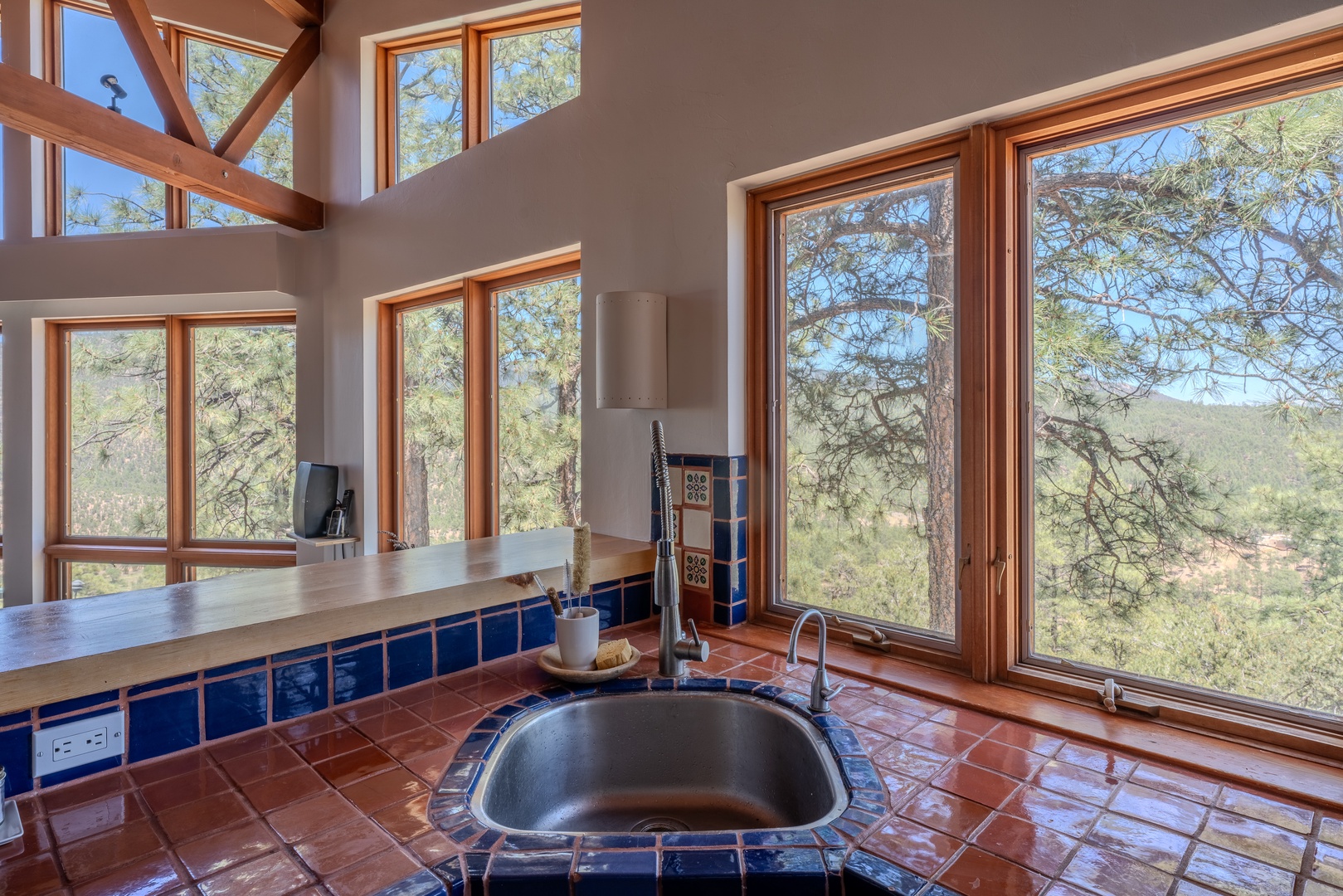 Stunning mountain and forest vistas frame the spacious kitchen, where soaring ceilings and abundant windows invite natural light into your culinary space.