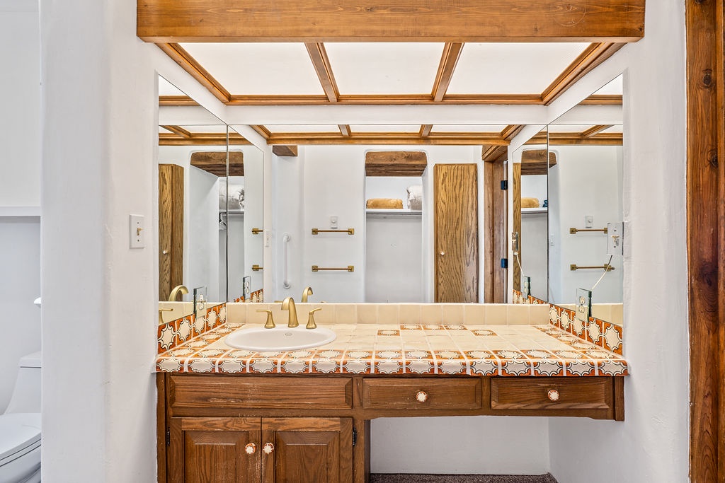 Beautiful rustic vanity with authentic wooden beams creates your perfect morning routine sanctuary with handcrafted tile details and elegant fixtures.