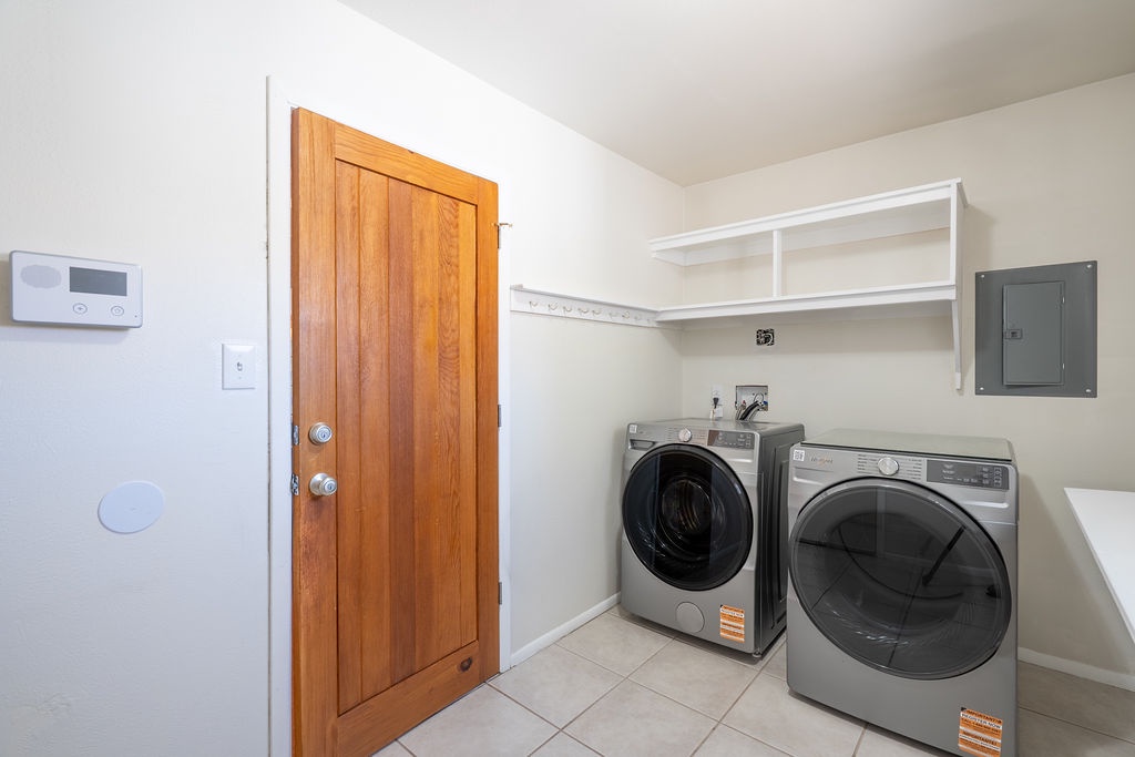 Your dedicated laundry space makes staying organized effortless with modern washer and dryer plus convenient shelving for supplies.