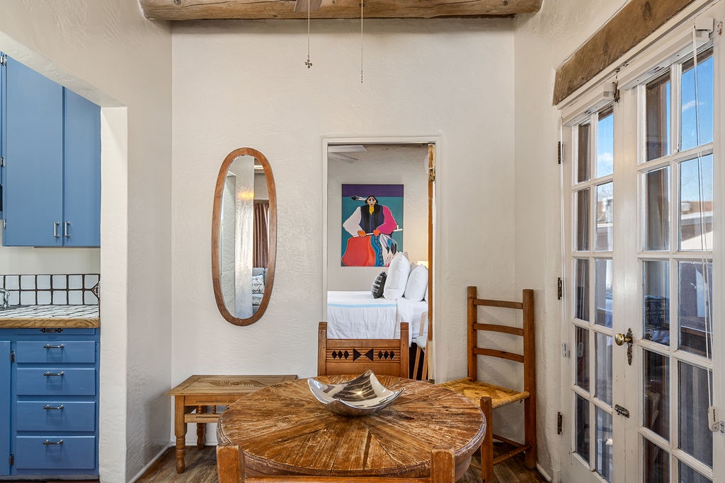 Gather around this rustic dining table where your morning coffee tastes better under authentic wooden beams and southwestern charm.