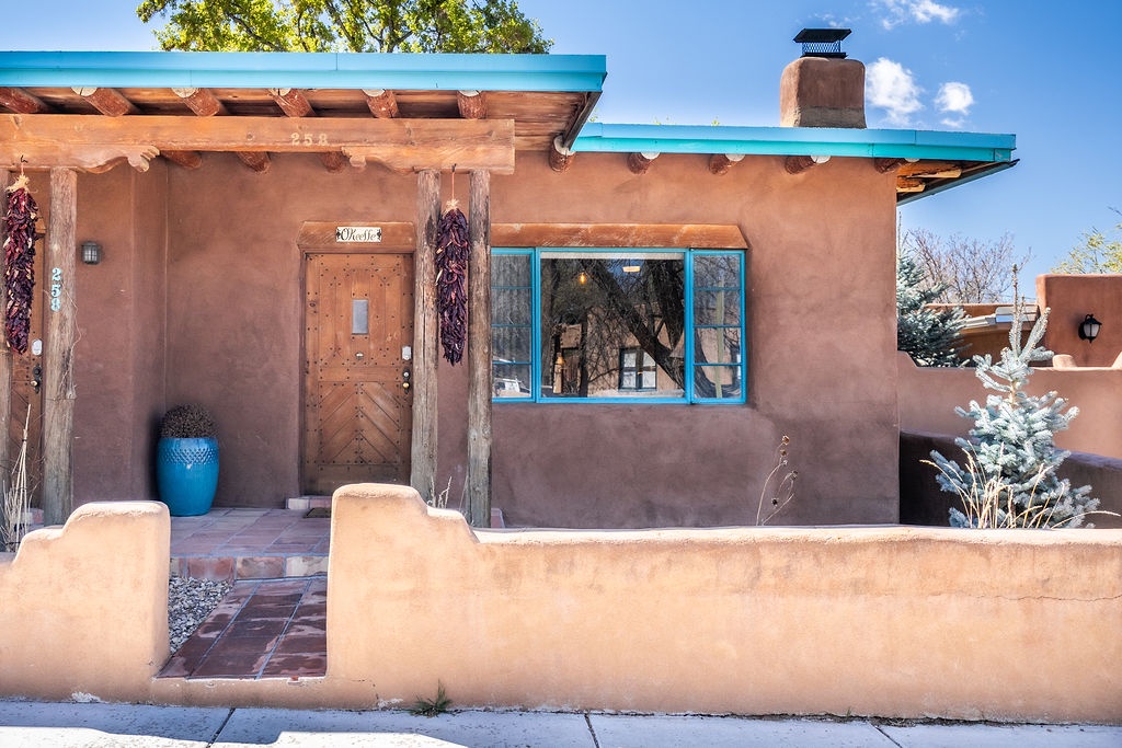 Classic Southwestern adobe architecture features traditional vigas, turquoise accents, and authentic pueblo-style design elements.