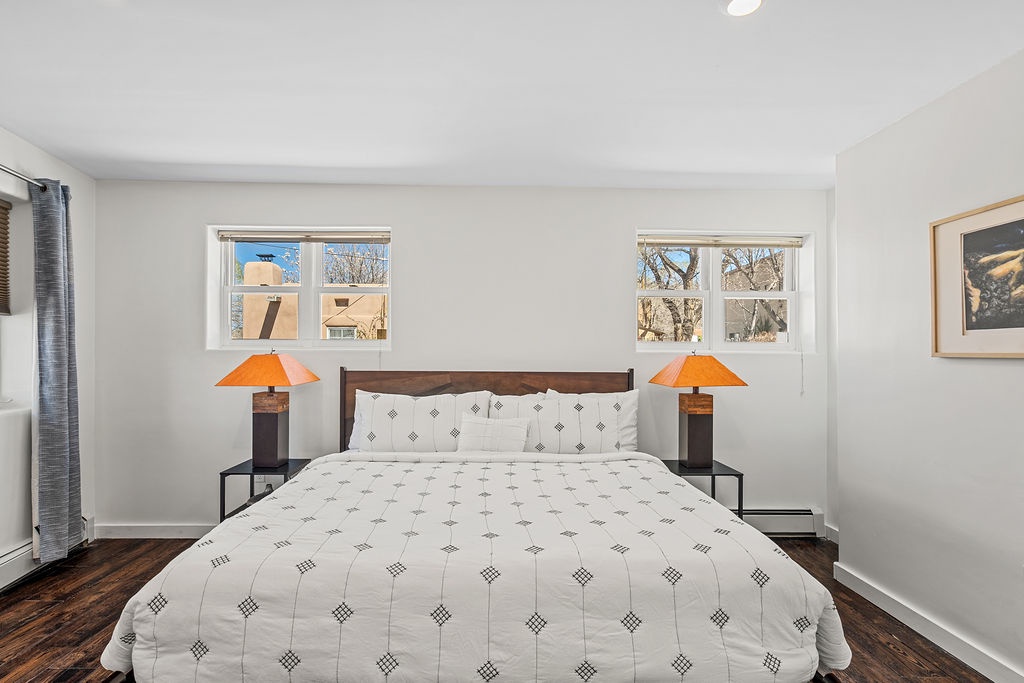 Wake up in your serene bedroom where warm orange lamps create a cozy glow and natural light streams through spacious windows.