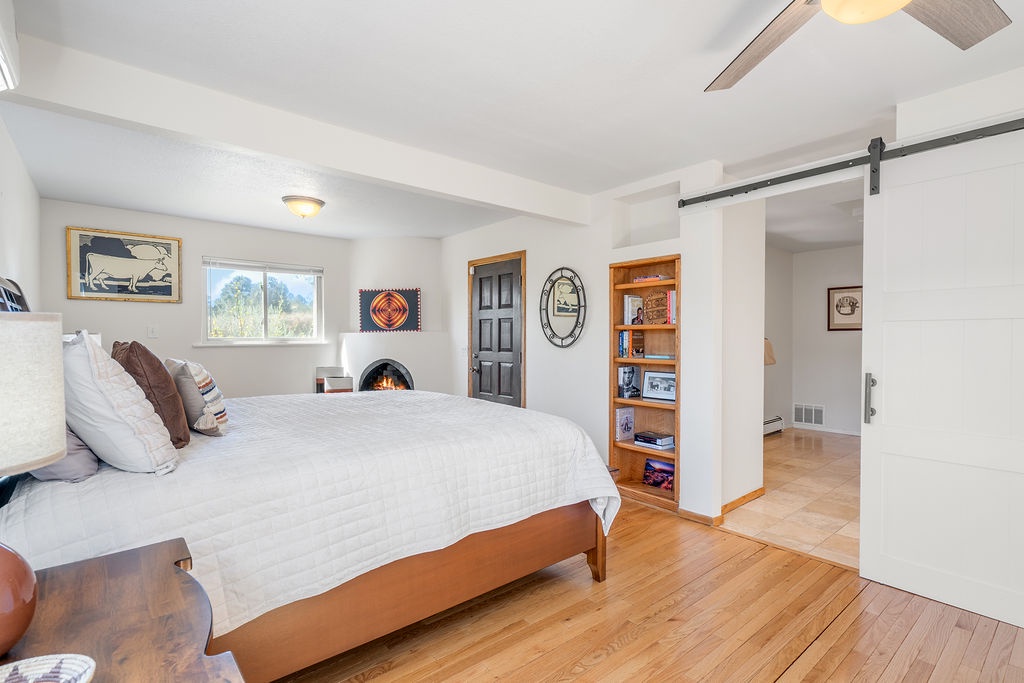 Unwind in your cozy bedroom with warm hardwood floors, charming fireplace, and built-in shelving for your belongings.