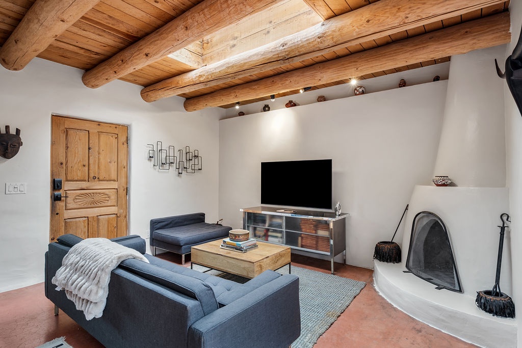 Unwind in your cozy living room, where exposed wooden beams meet modern comfort. Sink into plush seating by the fireplace.