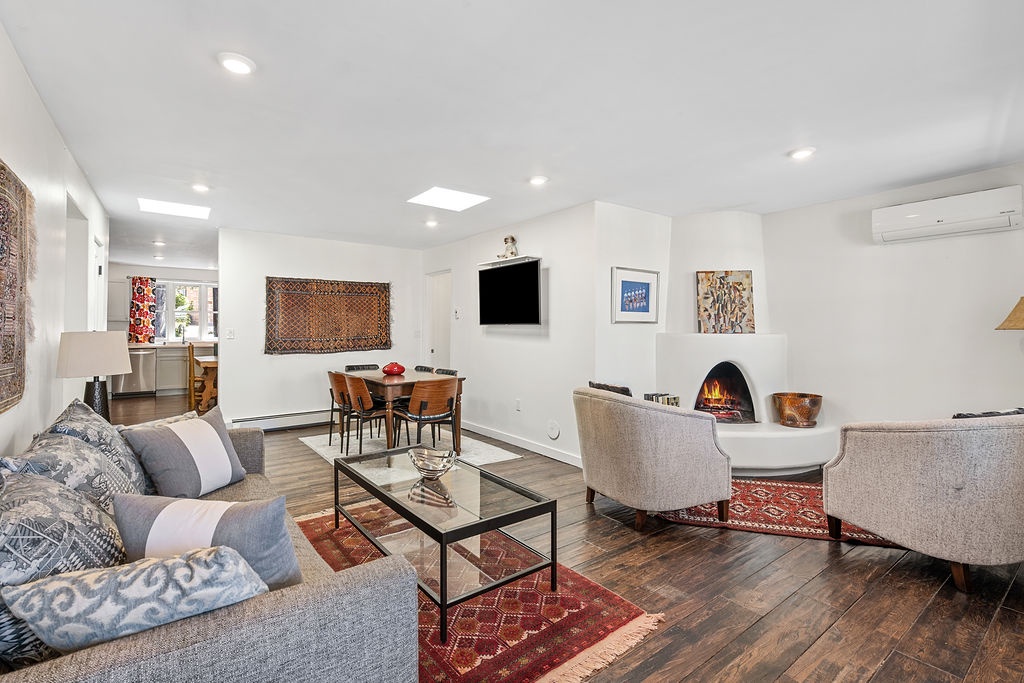 Relax in your stylish living room featuring a cozy fireplace, elegant furnishings, and warm wood floors—perfect for unwinding after exploring.