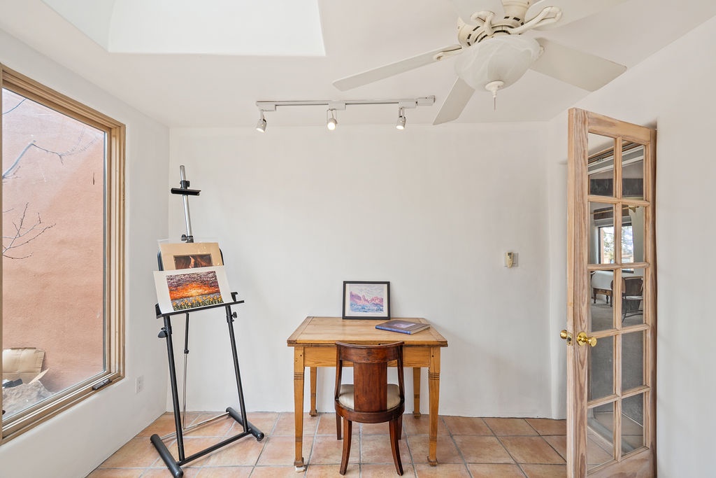 Your creative workspace awaits with an artist's easel, vintage desk, and natural light streaming through large windows.