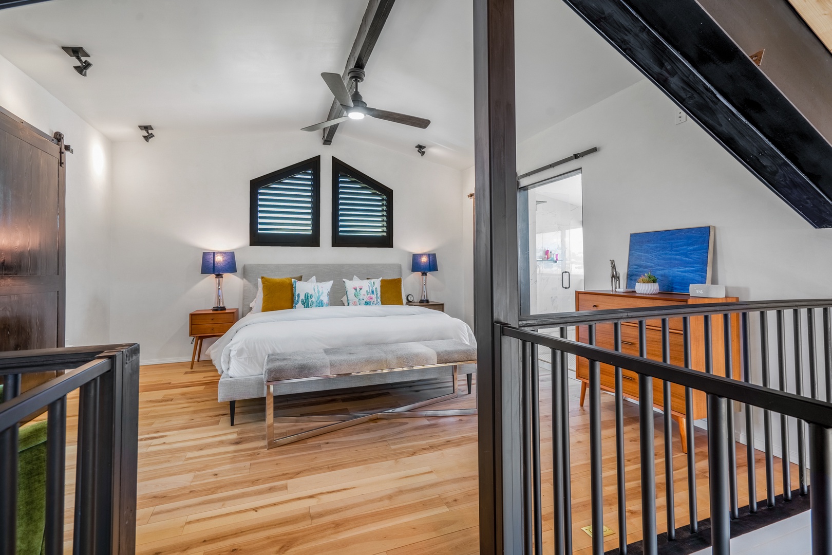 Your bright loft bedroom features exposed beams, warm wood floors, and tropical-themed bedding for peaceful island dreams.