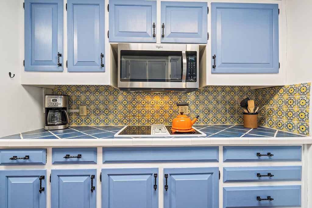 Your charming blue kitchen features colorful tile backsplash, modern appliances, and everything needed for cooking memorable meals.