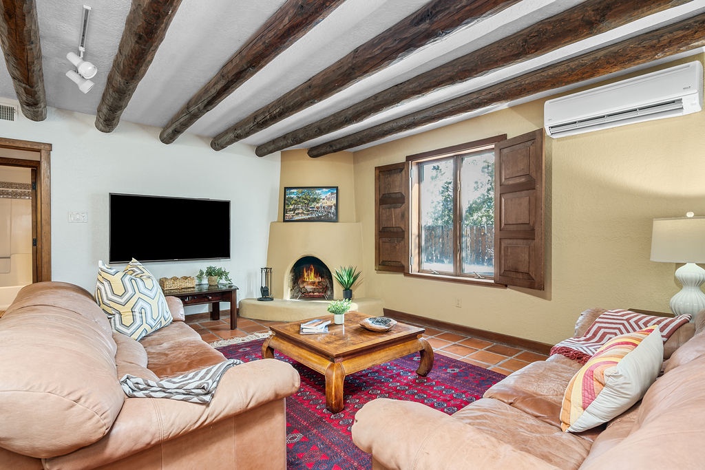 Unwind in your charming living room where rustic beams meet modern comfort, complete with a cozy fireplace and plush seating.