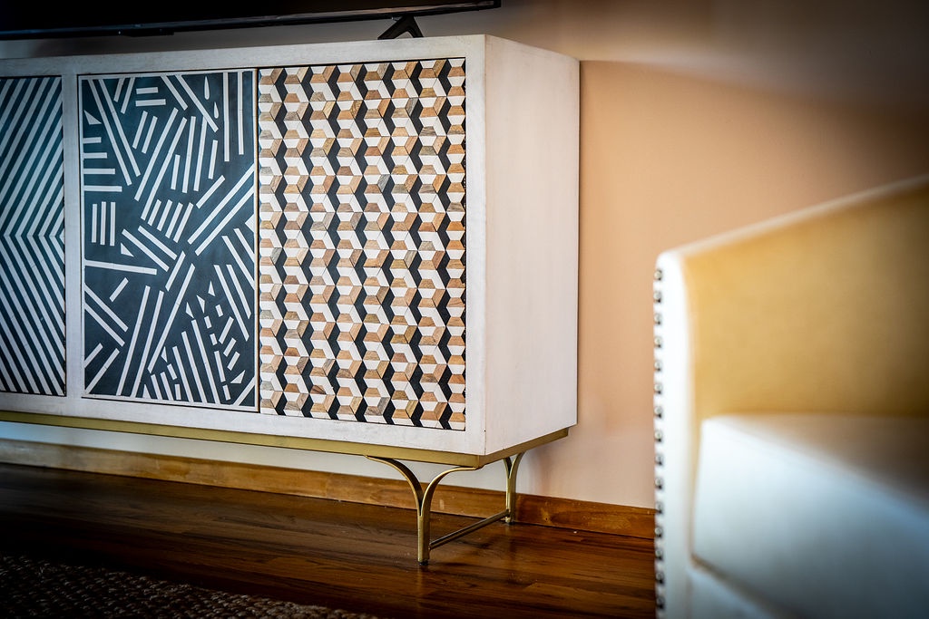 Relax in your stylishly appointed living space featuring contemporary geometric furniture and warm wood accents that create a welcoming atmosphere.