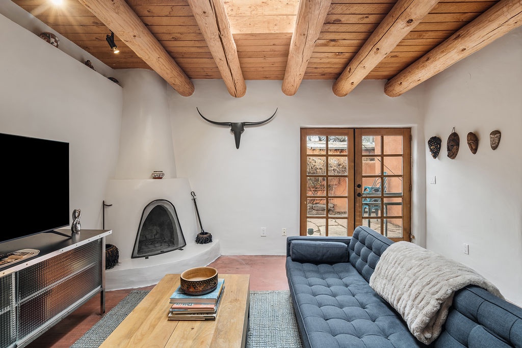 Cozy up in your stylish living room with exposed wooden beams and a charming adobe fireplace perfect for intimate evenings.