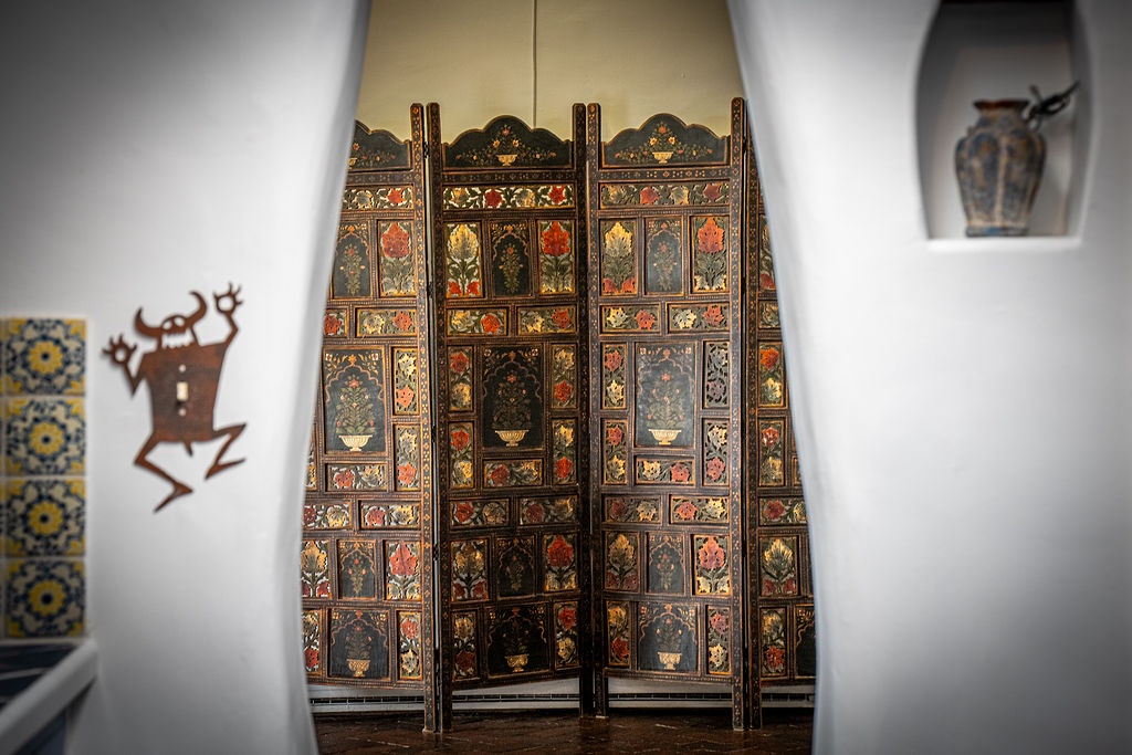 Step into a room where traditional artistry meets modern comfort, featuring an ornate hand-painted screen and cultural wall art that creates your own private cultural retreat.