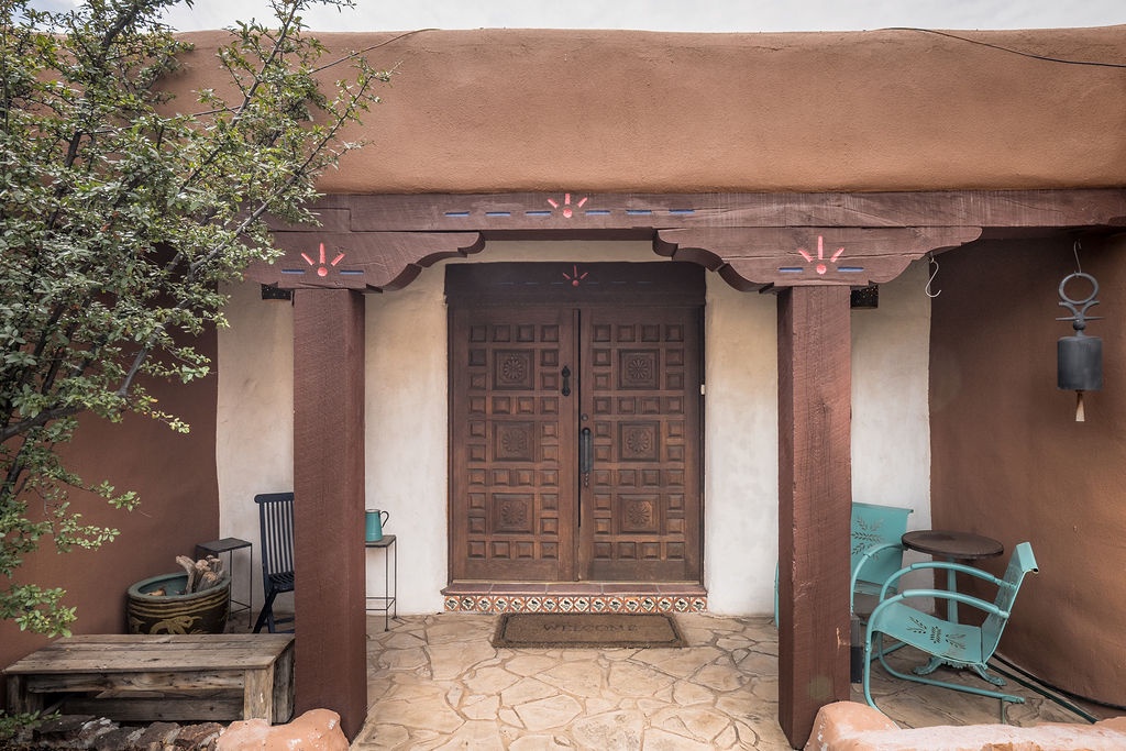Beautiful Adobe-style entrance with hand-carved wooden doors and authentic Southwest architectural details.