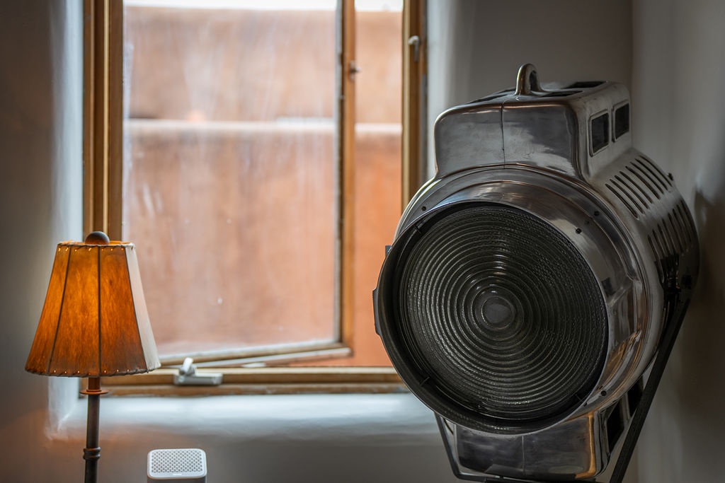 Discover unique charm in your cozy retreat, where vintage theater spotlights create magical ambiance beside warm lamplight and city views.