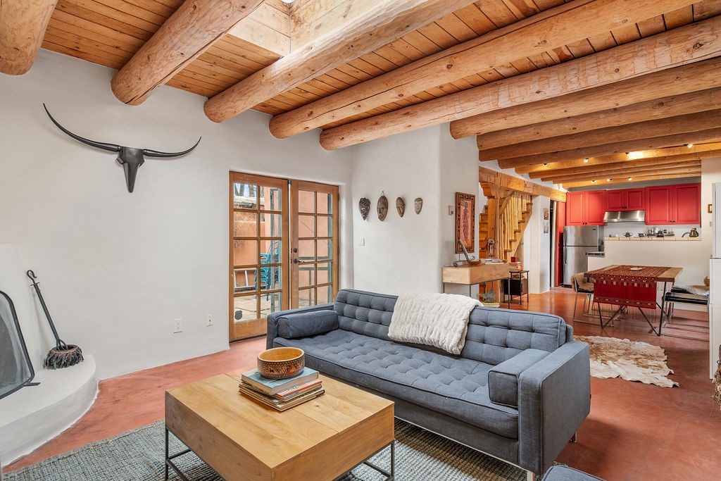 Relax in this stunning adobe-style living room where rustic wooden beams meet modern comfort, creating your perfect southwestern retreat.