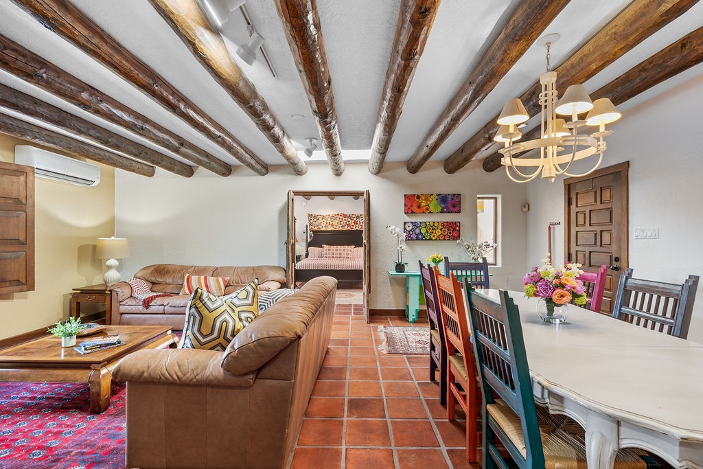 Relax in this stunning space where rustic wood beams frame vibrant art and comfortable seating, creating your perfect home base.