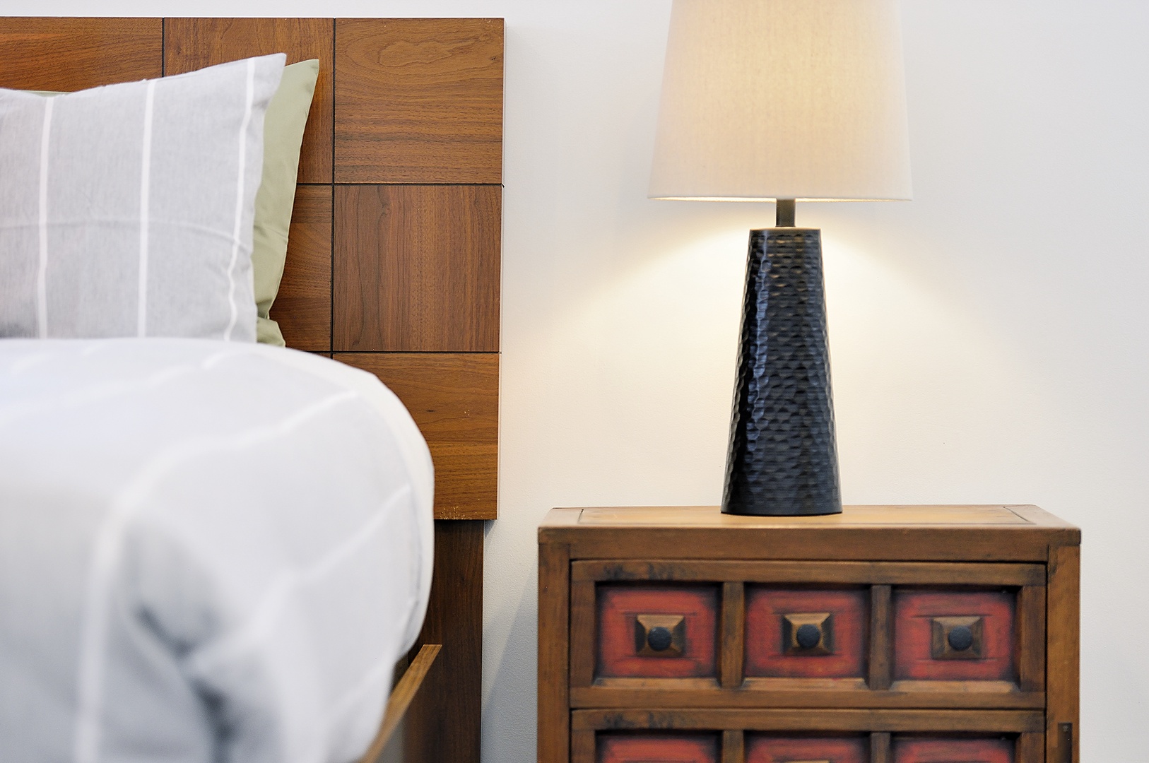Sink into crisp white bedding beside warm wood furnishings and soft lamplight for your perfect retreat.